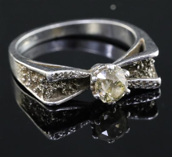 A platinum and single stone diamond ring, with diamond set shoulders and textured setting, size T.